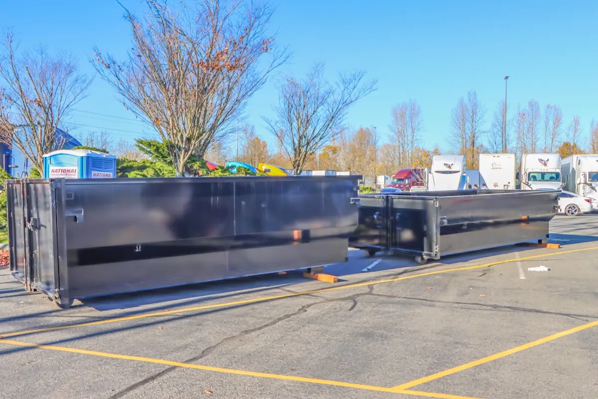 Professional dumpster rental service with roll-off container on residential driveway in East Grand Rapids